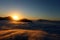 the sun at dawn with fog and backlit mountains