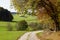 sun-drenched autumnal landscape with yellow trees and still green meadows in Bavarian countryside (Bavaria, Germany)