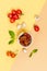 Sun dried tomatoes, champignon mushrooms, fresh tomatoes and basil leaves are ingredients on a yellow-orange pastel background.