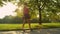 SUN FLARE: Golden sun rays shine on young woman riding an electric longboard.