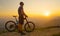 SUN FLARE Man stands next to his mountain bike while observing the sunlit nature