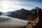 Sun flare over the Salmon Glacier as young blonde woman looks out over the scene