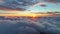 Sun goes into the clouds. Epic sunset in the sky, aerial shot. Flying above the clouds illuminated by the evening sun