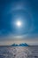 Sun Halo shining over the blue iceberg and ocean, North Greenland