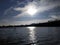 Sun hatching in a pond. Solar track. A city in the distance. Blue water and reflection of plants and sky in it. Scenery.