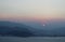 The sun is in the haze. The mountains. Sea. Sunset.