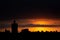 Sun is hiding behind the clouds at sunset, roof top view of an old church tower.