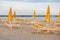 Sun loungers and closed umbrellas on the sea beach. Beach without people. Vacation concept