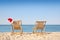 Sun loungers and Santa`s hat on beach, space for text. Christmas vacation