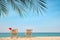 Sun loungers and Santa`s hat on beach, space for text. Christmas vacation