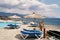 Sun loungers stand under umbrellas by the pool behind a fence