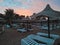 Sun loungers and straw umbrellas and beautiful sunset on the beach of Hurghada, Egypt