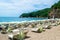 Sun loungers and umbrellas on the sandy Morgen beach located near the city of Budva. Summer sunny landscape. Montenegro