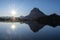 The sun and the Midi d`Ossau peak are reflected in Lake Gentau at dawn, Pyrenees.