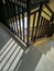 the sun in the morning shines on the iron staircase so that it casts beautiful shadows