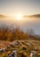 Sun over clouds mist in mountain landcape at sunrise