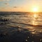 Sun over horizon and  rolling ocean waves to the shore while sunset during tide.  Beautiful natural landscape with water,  sandy