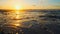 Sun over horizon and  rolling ocean waves to the shore while sunset during tide.  Beautiful natural landscape with water,  sandy