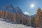 Sun over orange larches with Mount Pelmo background