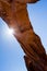 Sun peeking from behind the Pine Tree Arch in Arches National Park