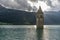 The sun peeps out from the top of the old bell tower of Curon Venosta, submerged in Lake Resia, South Tyrol, Italy