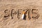 Sun protect factor fifteen. SPF 15 word written on the sand and white bottle with suntan cream. Skin care concept background