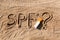 Sun protect factor. SPF word written on the sand and white bottle with suntan cream with question mark. Skin care concept