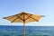 Sun-protecting beautiful natural umbrellas made of yellow fabric from dried branches against the blue sky, salt sea at a paradise