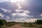 Sun rays burst through clouds on the rough road on the hilly mountains savannah Greenland grassland in the Maasai Mara Triangle Na