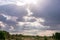 Sun rays burst through clouds wildebeest crossing the rough road on the hilly mountains savannah Greenland grassland in the Maasai