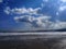 Sun rays bursting through clouds on Scarborough beach.