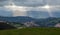 Sun rays through clouds and Cantabria landscape with field, montains and a small village. Spain