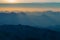 Sun rays illuminating mountain ranges through morning mist