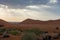 Sun rays pierce the stormy clouds above the sand dunes in the UAE