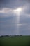 Sun rays shining through clouds onto hillside at the end of a March afternoon in England