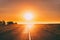 Sun Rising Above Asphalt Country Open Road In Sunny Sunrise Morning. Open Road In Summer Or Autumn Season At Sunny