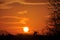 Sun rising over rural landscape, with sky and clouds glowing