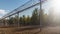 The sun`s rays and autumn trees are visible through the metal prison fence with barbed wire. 3D Rendering