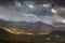 The sun`s rays break through the dark gray clouds. Impressive view of the mountains of Sarek national park in Swedish Lapland.