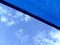 Sun sail. loosely weaved blue fabric sun shade material spanning over terrace area. blue sky and cluds