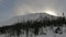 Sun sets behind big white hill covered with thick snow