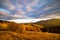 Sun sets behind forestry mountains in highland in autumn