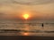 The sun sets on the horizon where the sea joins the sky. people-adult and child-swim in the sea and enjoy the Golden sunset on the