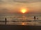 The sun sets on the horizon where the sea joins the sky. people-adult and child-swim in the sea and enjoy the Golden sunset on the