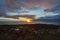 The sun sets just above the horizon along the Atlantic Ocean, photographed near the coast by the Grotta Island Lighthouse,
