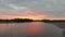 the sun sets over the river mouth and mangrove trees