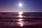 The sun sets over the sea at sunset, on the horizon, it looks like a fake star. the sea is calm in front of a sandy beach