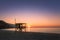 Sun setting behind lifeguard tower on Ostriconi beach in Corsica