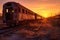 sun setting behind line of decaying train cars