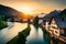 The sun setting behind a Swiss village by the river, casting a warm, golden glow on the traditional houses and surrounding